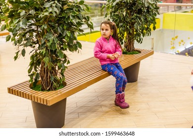 Little Girl Alone In Shopping Mall Center, Looking For Her Mother. The Child Was Lost In The Big Store.