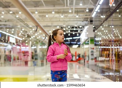 Little Girl Alone In Shopping Mall Center, Looking For Her Mother. The Child Was Lost In The Big Store.