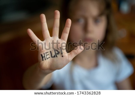 Little girl asks for help, help written on hand. Domestic and child abuse. Protecting the rights of the child.