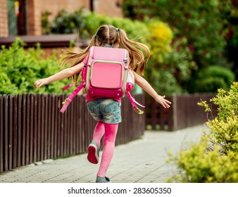 Little Girl With A Backpack Run  To School. Back View