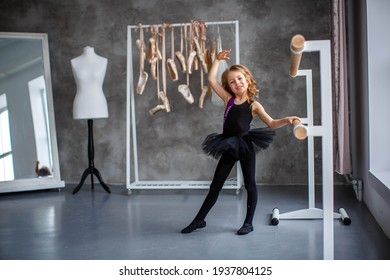 little girl ballerina in a black tutu at the machine