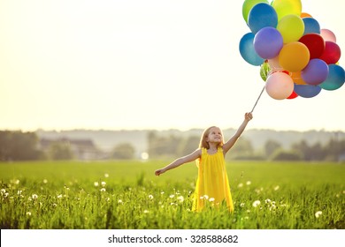 Little girl with balloons in the field