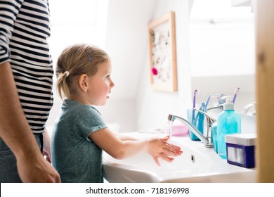 Little girl in bathroom with father washing hands. - Powered by Shutterstock