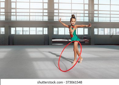 Little girl in beautiful dress dancing with hoop in gym-hall - Powered by Shutterstock