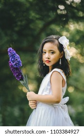 Little girl in a beautiful dress in a garden at sunset in Hanoi, Vietnam.
