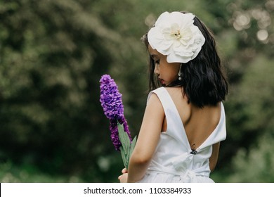 Little girl in a beautiful dress in a garden at sunset in Hanoi, Vietnam.