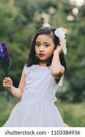 Little girl in a beautiful dress in a garden at sunset in Hanoi, Vietnam.