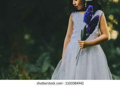 Little girl in a beautiful dress in a garden at sunset in Hanoi, Vietnam.