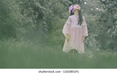 Little girl in a beautiful dress in a garden at sunset in Hanoi, Vietnam.