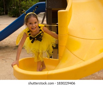 Little Girl In A Bee Costume Having Fun In A Kids Playground 