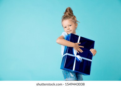 Little Girl With Big Blue Present In The Box With White Ribbon. New Year Gift Concet.