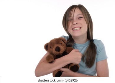 Little Girl With Big, Cheshire Cat Grin, Smiling And Sitting On Floor Holding A Teddy Bear.  Shot On White.