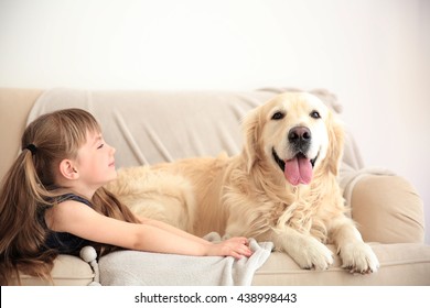 Little Girl And Big Kind Dog On Sofa