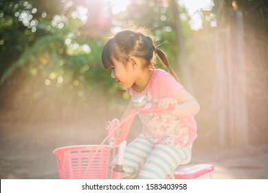 Little Girl Bikes A Bicycle With Training Wheels. Sport And Recreation Activity Outdoor For Kids And Parents.