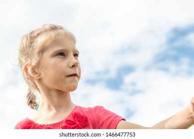 little girl, blonde, playing in the meadow, and blows a bubble