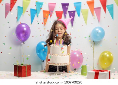 Little Girl Blowing Candles On A Birthday Cake