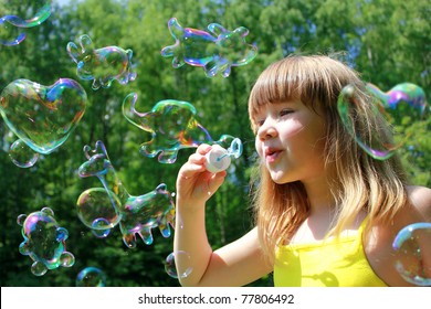 Little girl blowing funny animals shaped soap bubbles