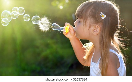 Little Girl Blowing Soap Bubbles