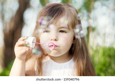 Little Girl Blowing Soap Bubles