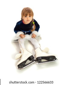 Little Girl In Blue Dress With Too Big Skates On Feet