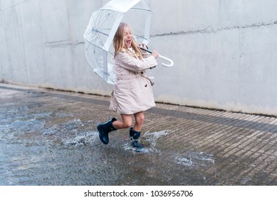 little girl with blue eyes  and big clear umbrella. Stock Photo