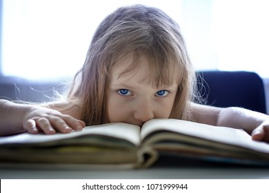 A Little Girl With Blue Eyes Reads A Book. Indigo Children