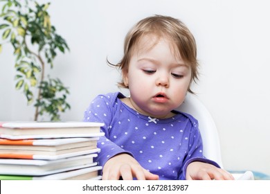 Little Girl With Books With A Business Look Does Not Look At The Camera. The Concept Of Education And Development Of Children