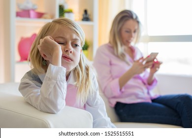 Little girl  is bored while her mother is using phone