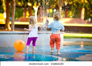 Little Girl And Boy Having Fun With The Water