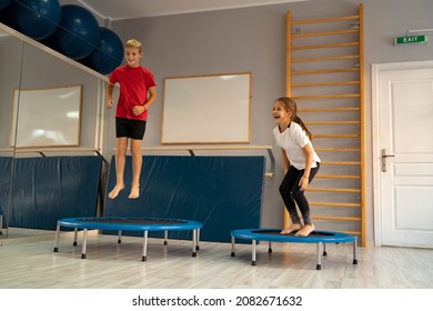 Little girl and a boy jumping on a trampoline in the gym and having fun. Image contains little noise   - Shutterstock ID 2082671632