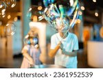 Little girl and boy make soap bubbles, while playing together and having fun in a science museum. Concept of children