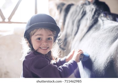 Little girl brushing her pony in the farm - Powered by Shutterstock