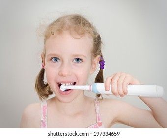 Little Girl Brushing Her Teeth With Electric Toothbrush.