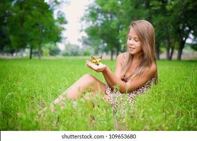 Little girl with a butterfly in his hands.