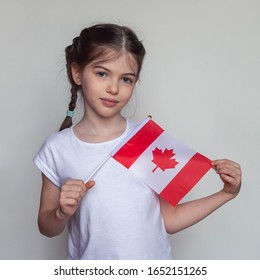 Little Girl With Canadian Flag On A White Background. Study, Immigration To Canada