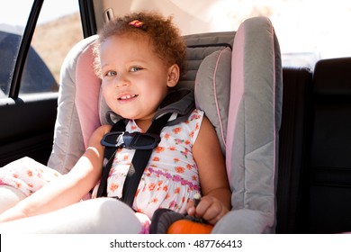 Little girl in a car seat.