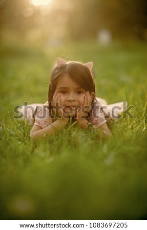 Similar – Littel girl sitting on grass looking curious