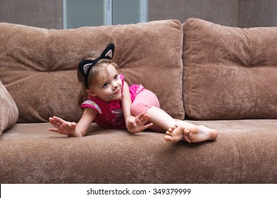 Little Girl With Cat Face Painting On A Couch