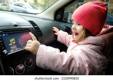 A Little Girl Changing Radio Station While Listening Music In Car. Listening To The Radio In The Car. Auto Music