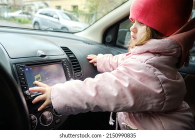 A Little Girl Changing Radio Station While Listening Music In Car. Listening To The Radio In The Car. Auto Music