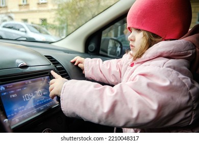 A Little Girl Changing Radio Station While Listening Music In Car. Listening To The Radio In The Car. Auto Music