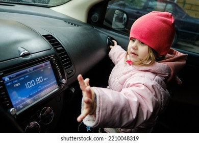 A Little Girl Changing Radio Station While Listening Music In Car. Listening To The Radio In The Car. Auto Music