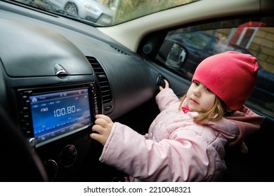 A Little Girl Changing Radio Station While Listening Music In Car. Listening To The Radio In The Car. Auto Music