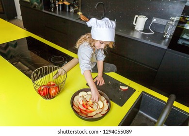 Little Girl With Chef Hat Preparing Bake Homemade Holiday Apple Pie In Kitchen. Kid Cooking Healthy Food At Home And Having Fun. Childhood, Household, Teamwork Helping Concept