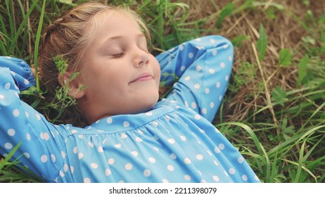 little girl child lies on the grass in the park. happy family kid dream concept. baby girl in the park lies on fun her back looks at the sky portrait close-up. girl in nature smiling portrait - Powered by Shutterstock