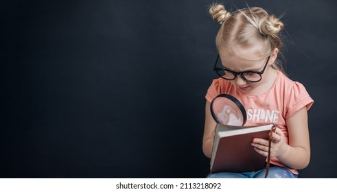 Little Girl Child Looking Through A Magnifying Glass On Black Background. Education, Back To School Concept. Home Schooling