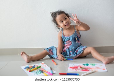 Little Girl Child Showing Front Teeth With Big Smile And Raise Three Fingers While Learning To Paint On Drawing On Paper During Her Painting Time.With Line And Shape On The White Paper.