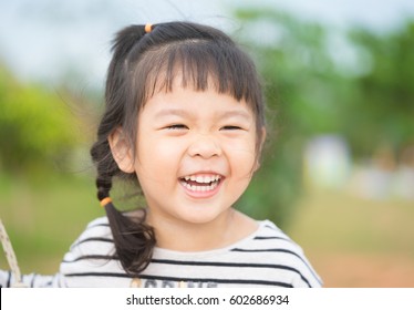 Little Girl Child Showing Front Teeth With Big Smile: Healthy Happy Funny Smiling Face Young Adorable Lovely Female Kid With New Tooth Dental Loss: Joyful Portrait Of Asian Elementary School Student