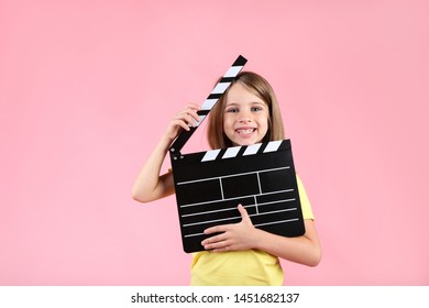 Little Girl With Clapper Board On Pink Background