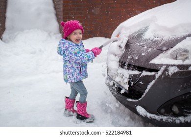 Little Girl Cleans A Car From The Snow